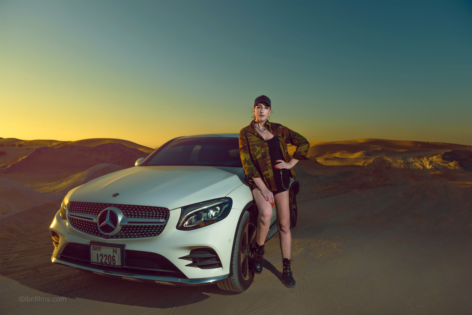 Fashion lifestyle photoshoot in Dubai UAE featuring a stylish model in a short skirt standing beside a white Mercedes car